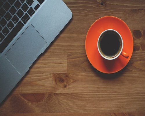 A clean, well-lit home office desk space with a cup of tea, emphasizing the need for breaks