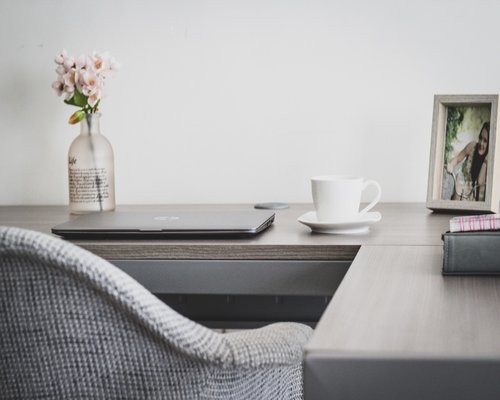 Organized desk space at home with natural light, emphasizing separation of work and rest areas